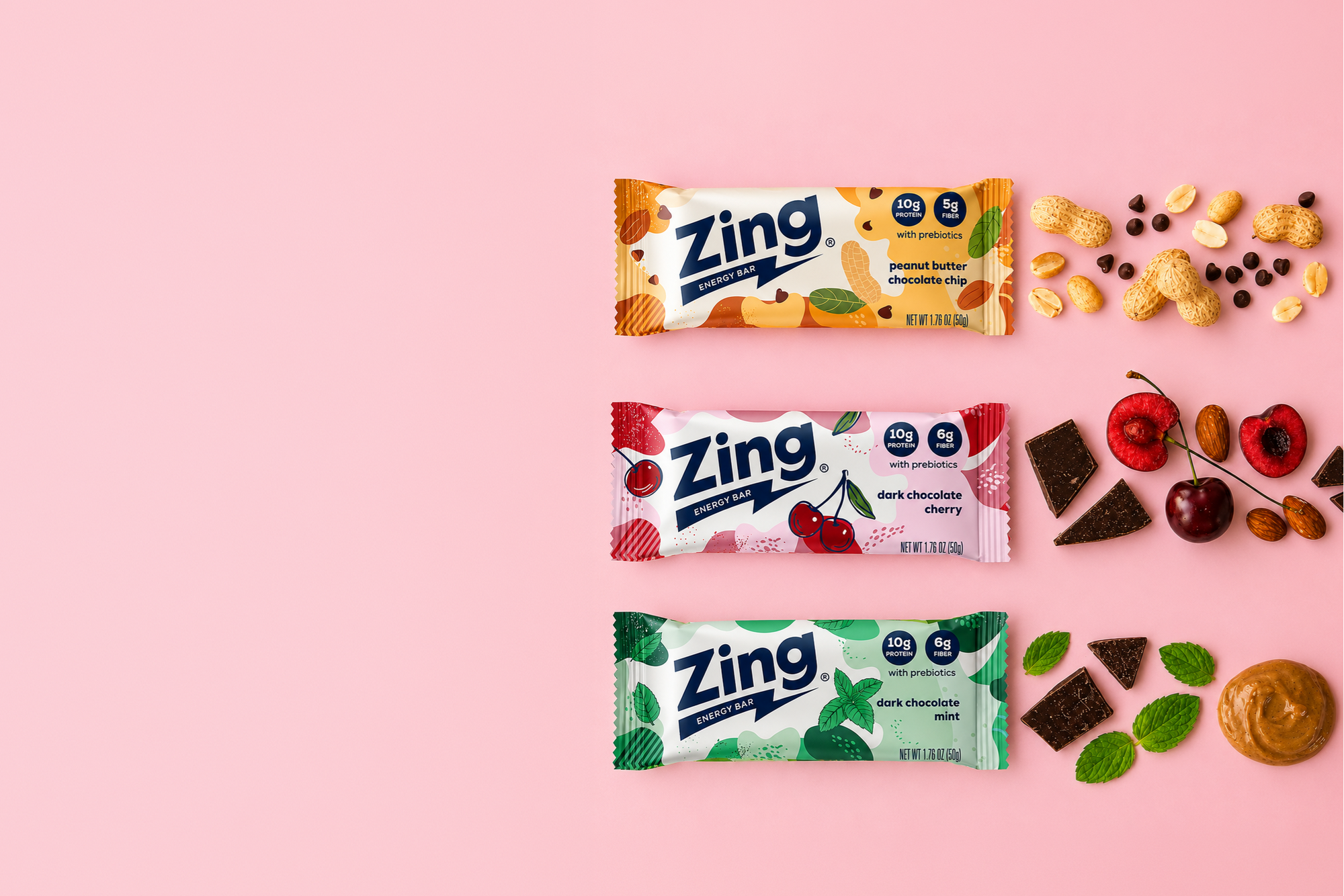 Zing energy bar packages on a pink background with various snacks.